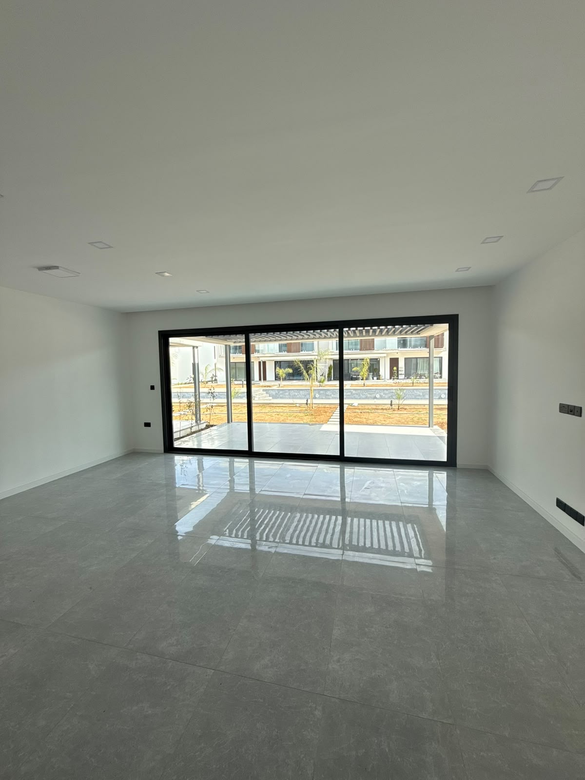 Empty living room with panoramic sliding doors to the back yard