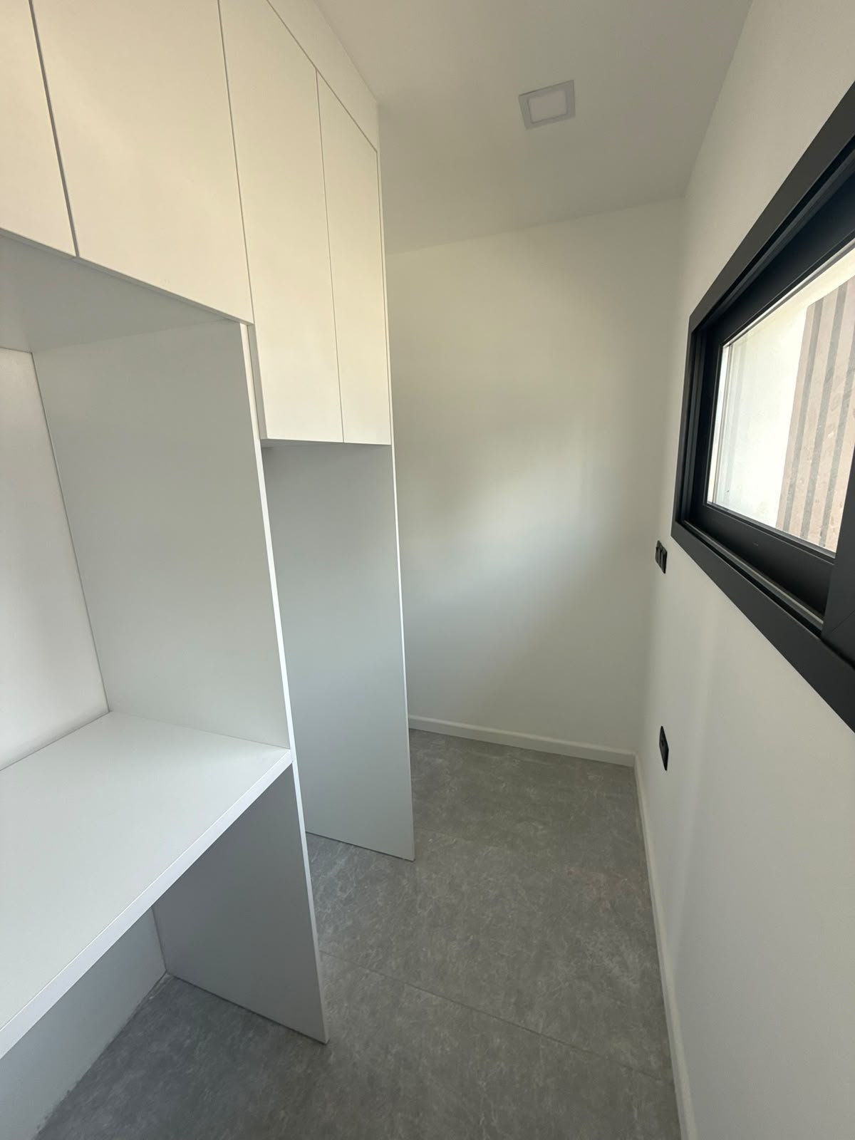 Storage room with built-in cabinets and a window