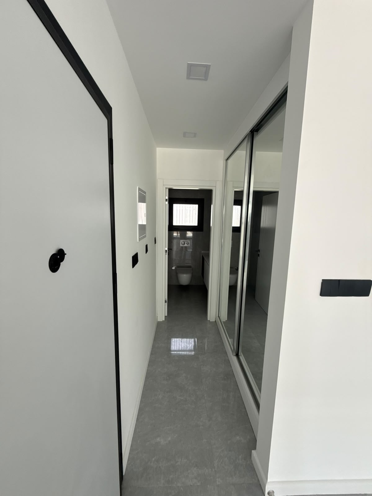 Hallway with a mirrored sliding wardrobe and a view into the bathroom