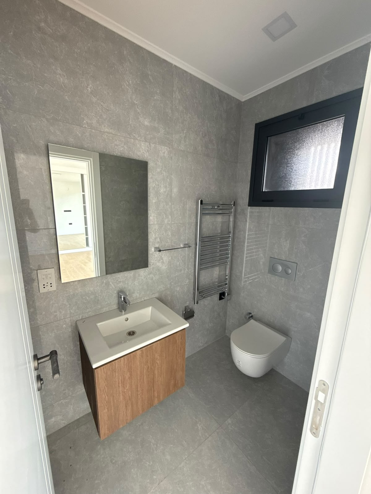 Bathroom with a wood-finish vanity and a heated towel rail