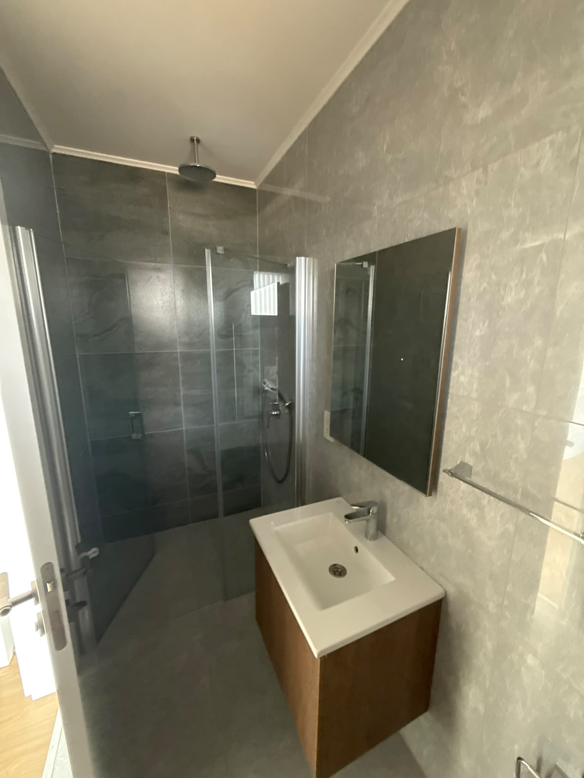 Bathroom with a glass shower cabin and a mirrored cabinet