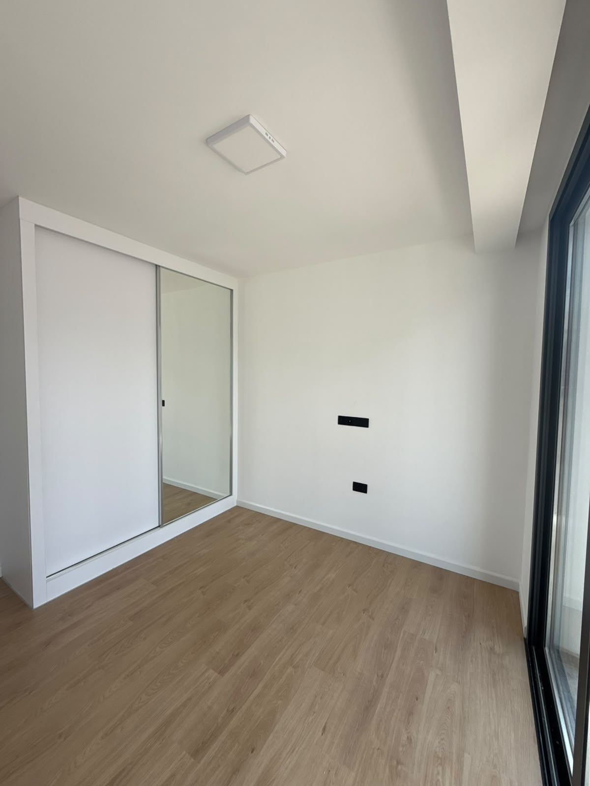 Bedroom with a built-in wardrobe and a window