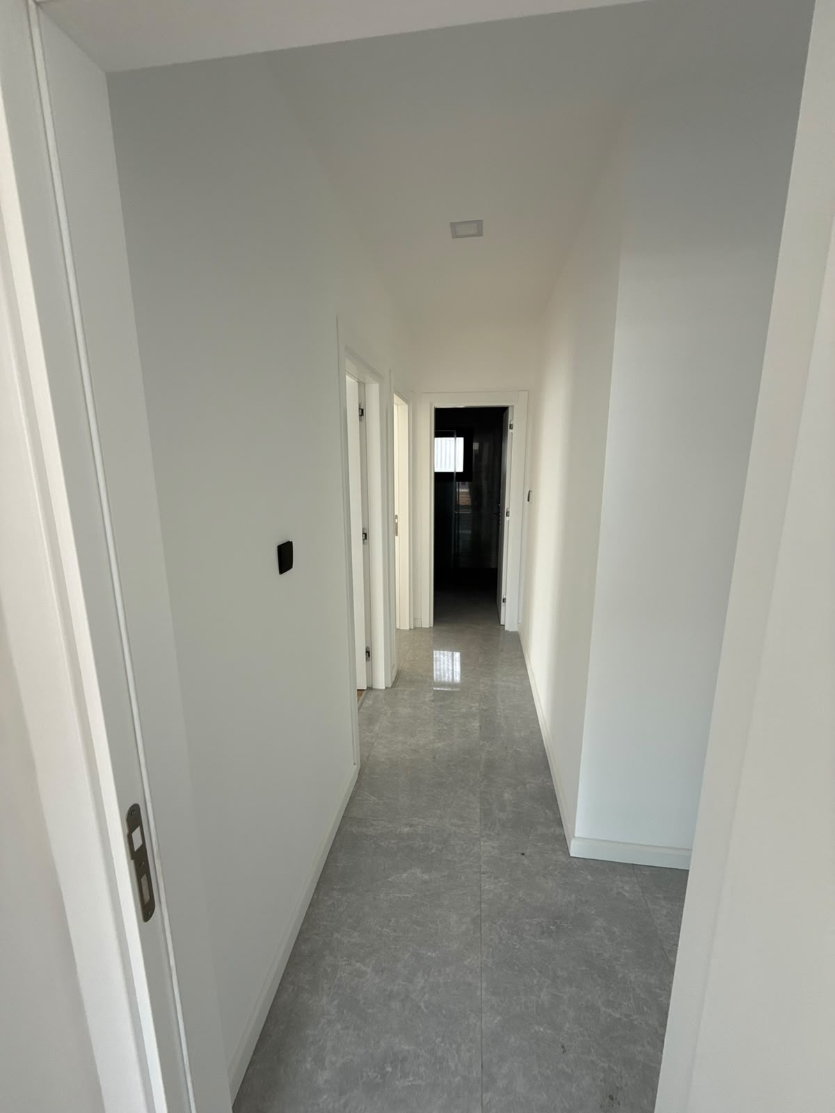 Hallway with several doors, tiled flooring