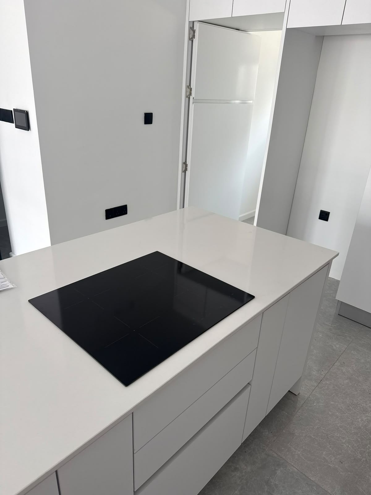 Close-up of the kitchen island: cooktop and built-in fridge