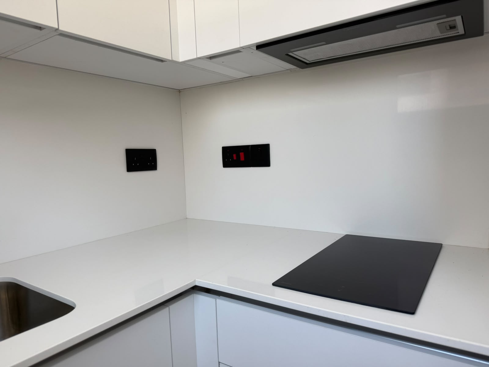 Close-up of the kitchen: cooktop and wall sockets