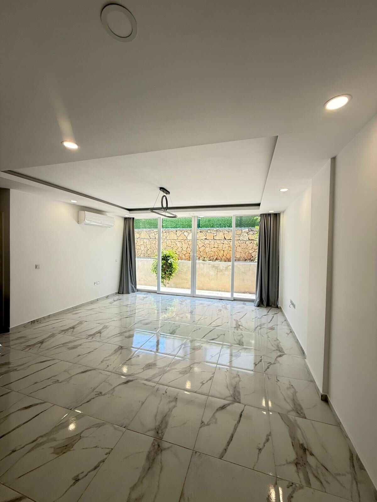 Bedroom with sliding glass door to the garden and a view of the stone wall