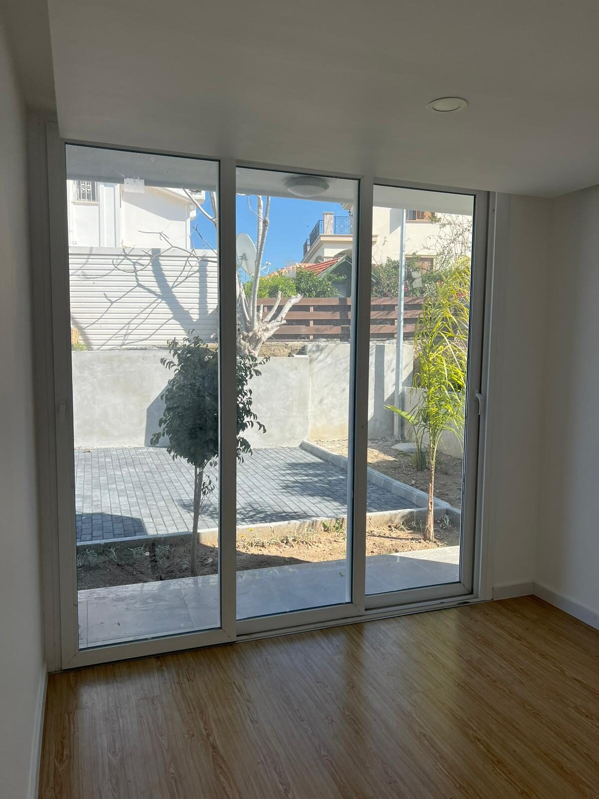 Bedroom with sliding glass door, view of neighboring houses and trees