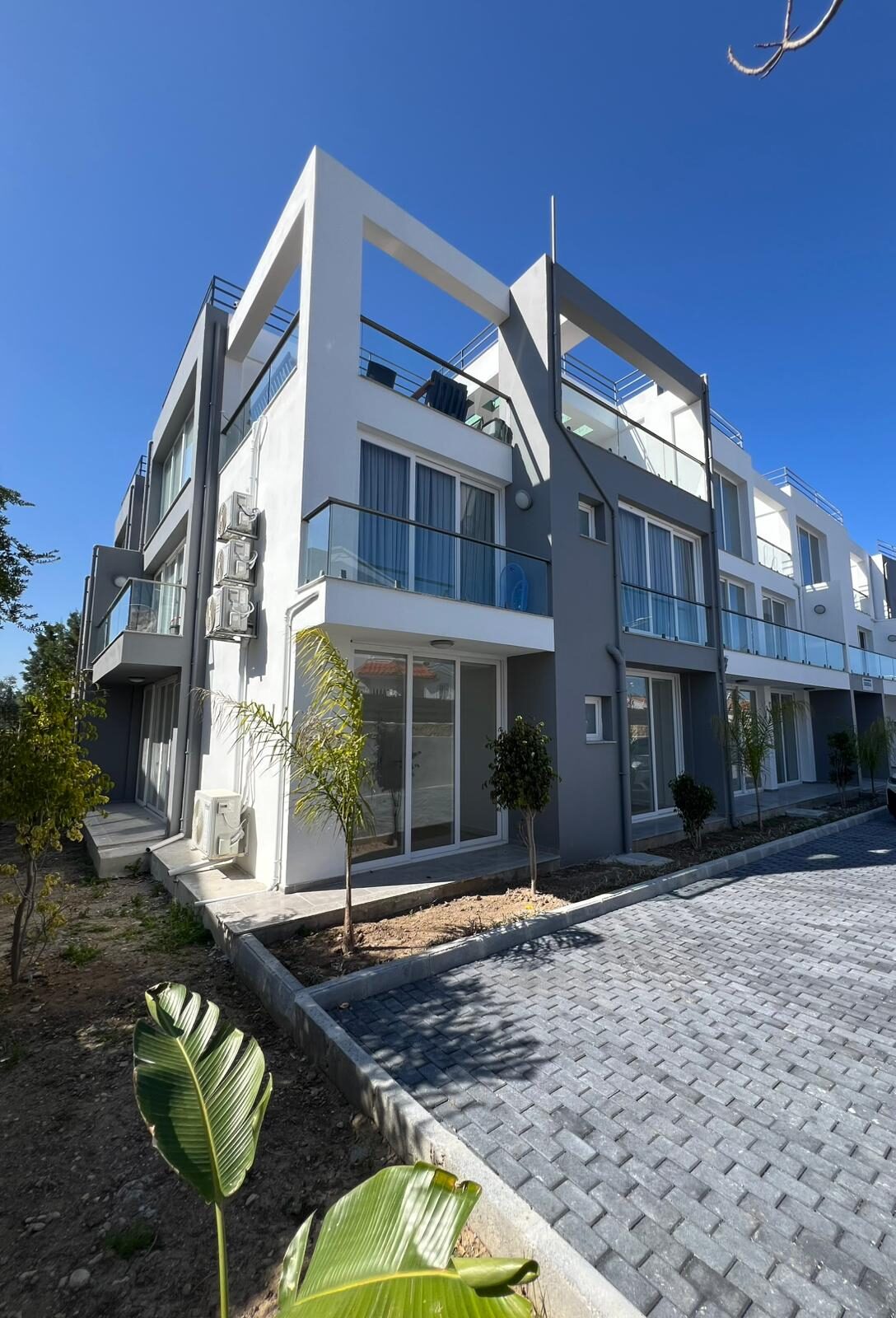 Corner of the building: ground-floor terrace and entrance with landscaping