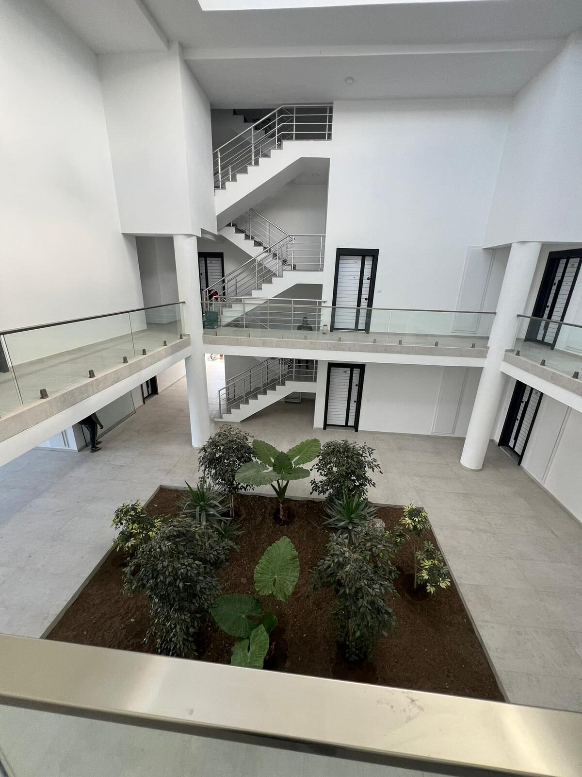 Interior courtyard atrium of the complex with staircases and greenery, view from above