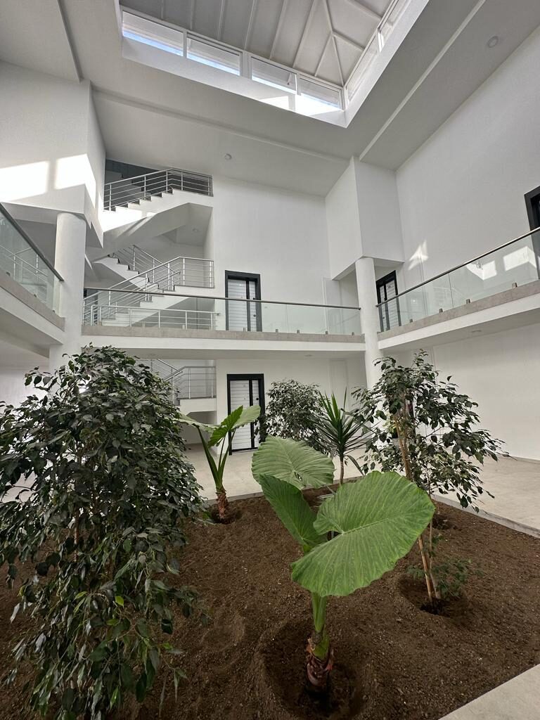 Interior courtyard atrium of the complex with staircases and greenery, view from below