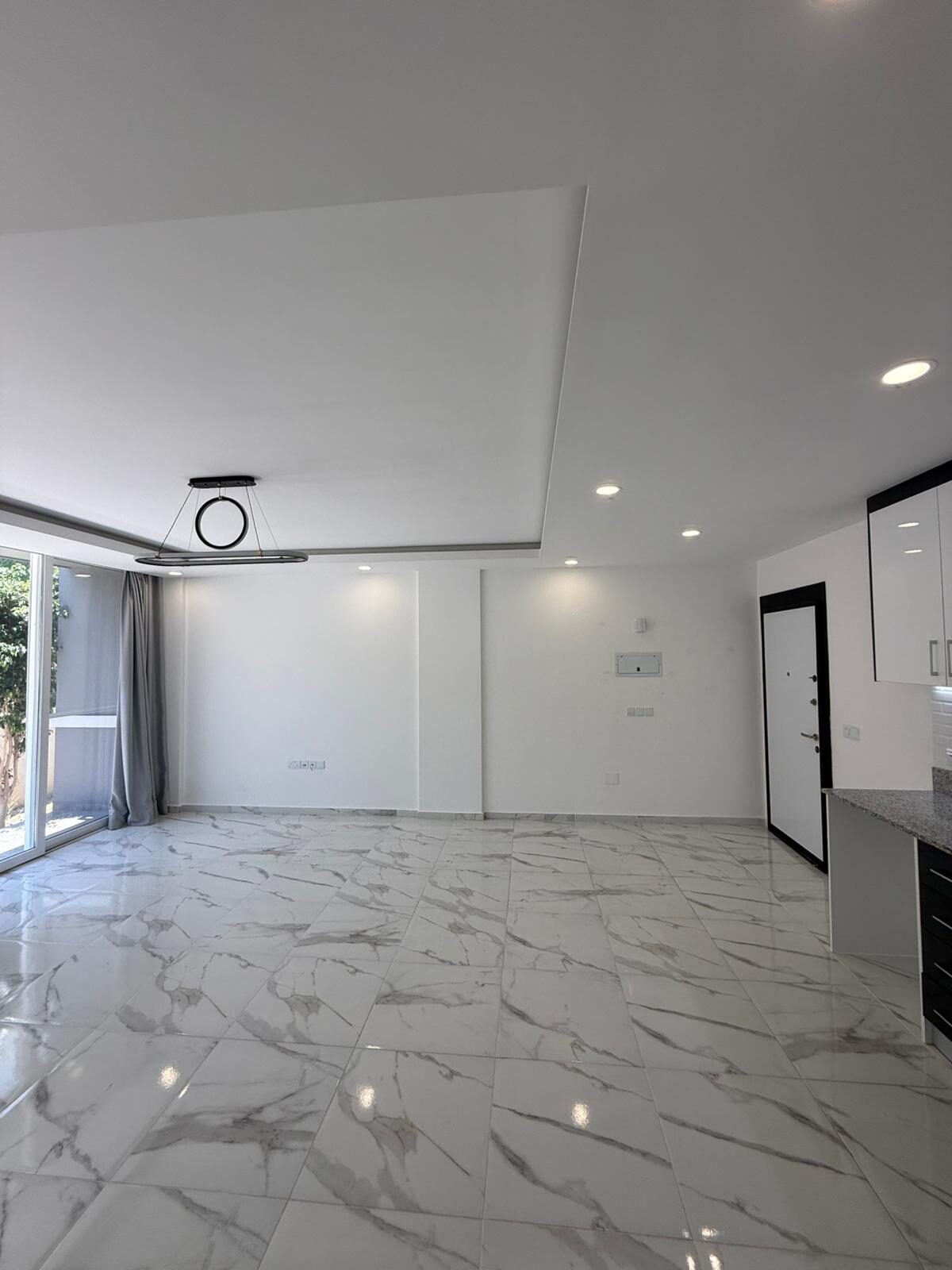 2+1 living room in Coliseum Court: empty room with marble flooring