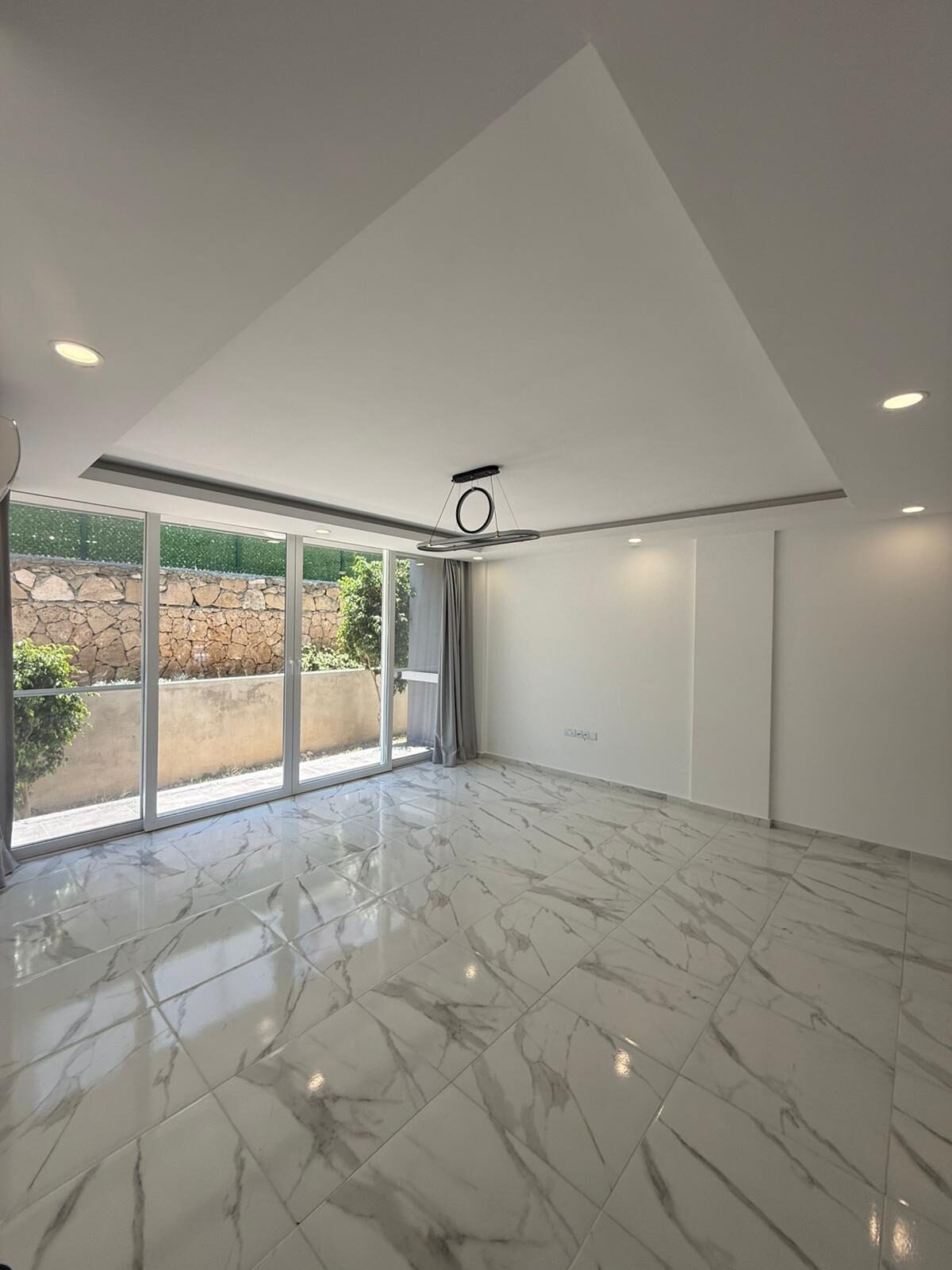 Living room with sliding doors to the back yard and a view of the stone wall