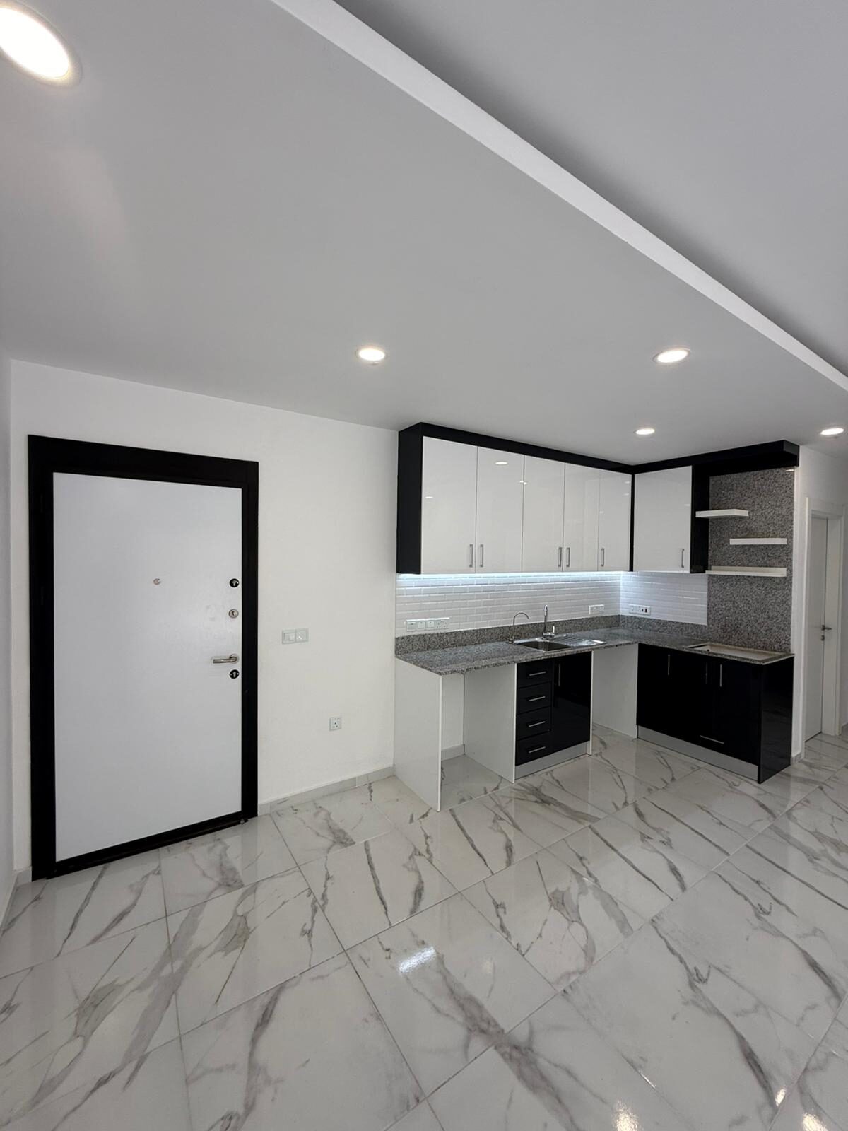 Close-up of the kitchen: sink, countertop, cabinets above the work area
