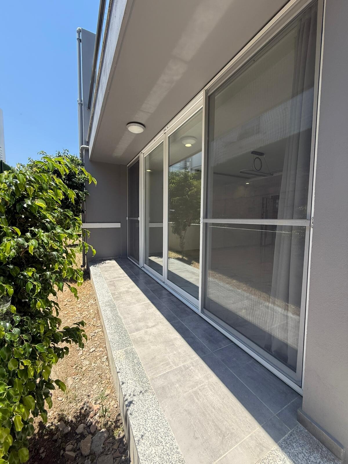 Covered terrace of the apartment with panoramic sliding doors
