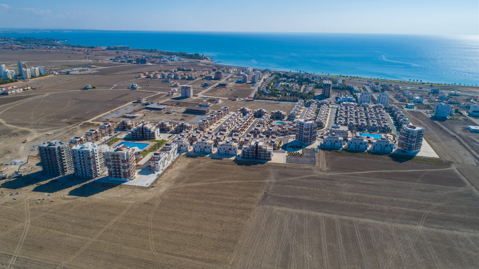 Royal Sun Residence from the air: low-rise buildings, pools and the Mediterranean on the horizon