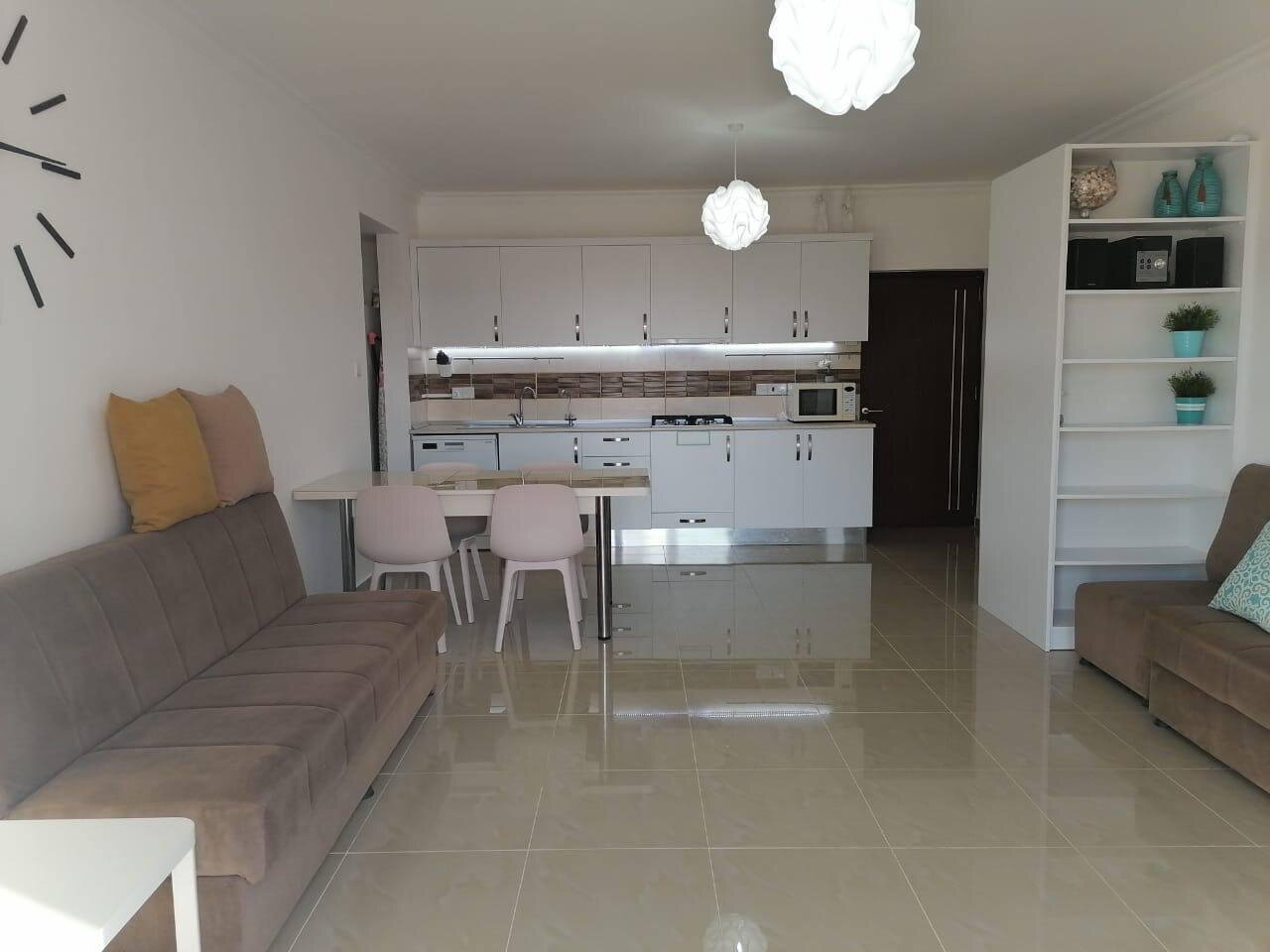 Open-plan living room and kitchen: sofa, dining table and the kitchen along the far wall