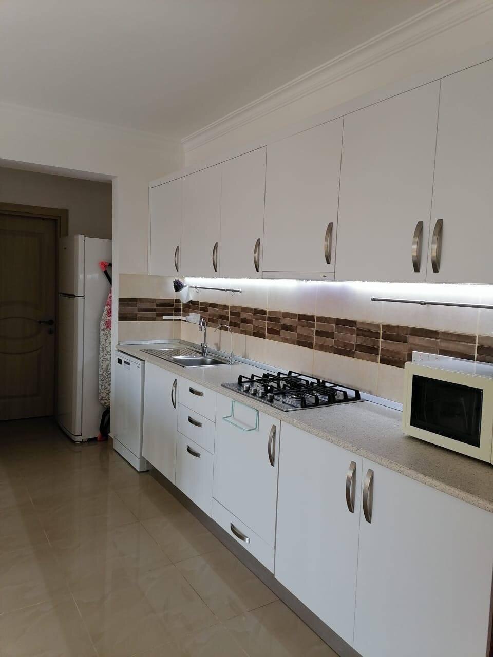 Kitchen close up: gas hob, dishwasher and microwave