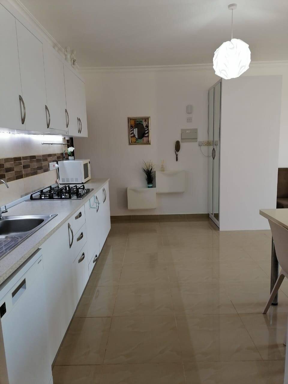 Kitchen along the wall with fitted units and the way through to the hall