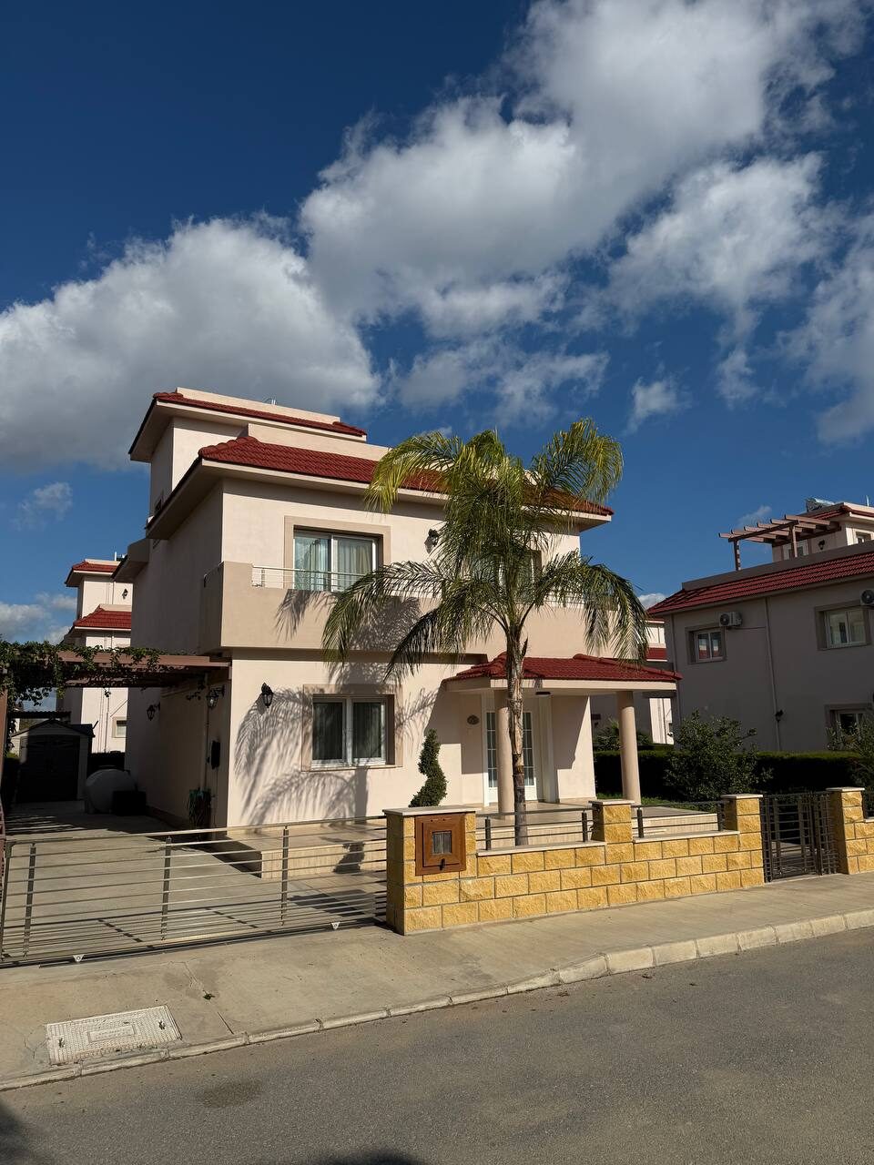 Sea Pearl Residence villa from the street: two storeys, red tiled roof and a palm by the entrance