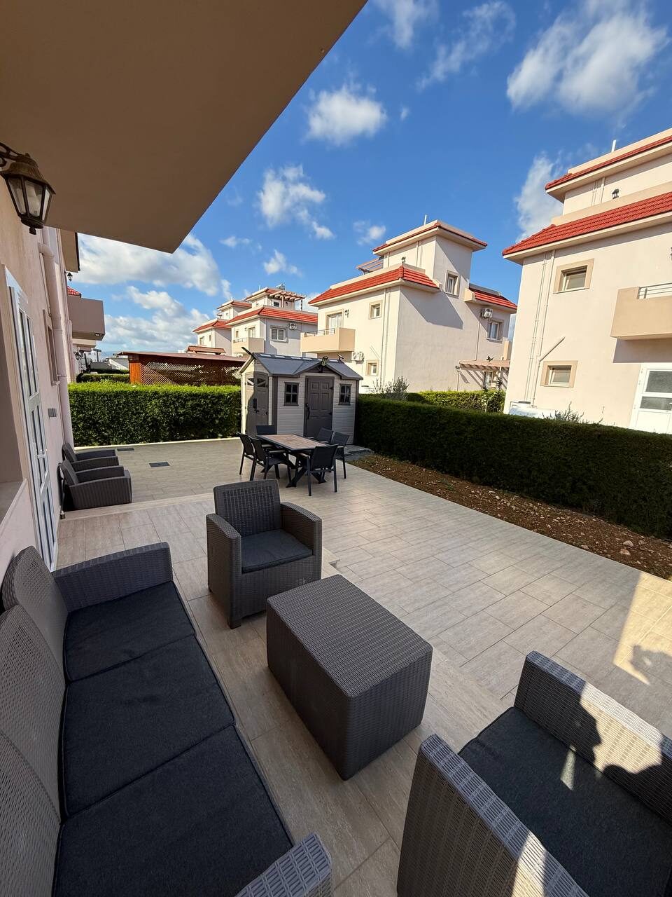 Covered terrace with a rattan sofa and armchairs