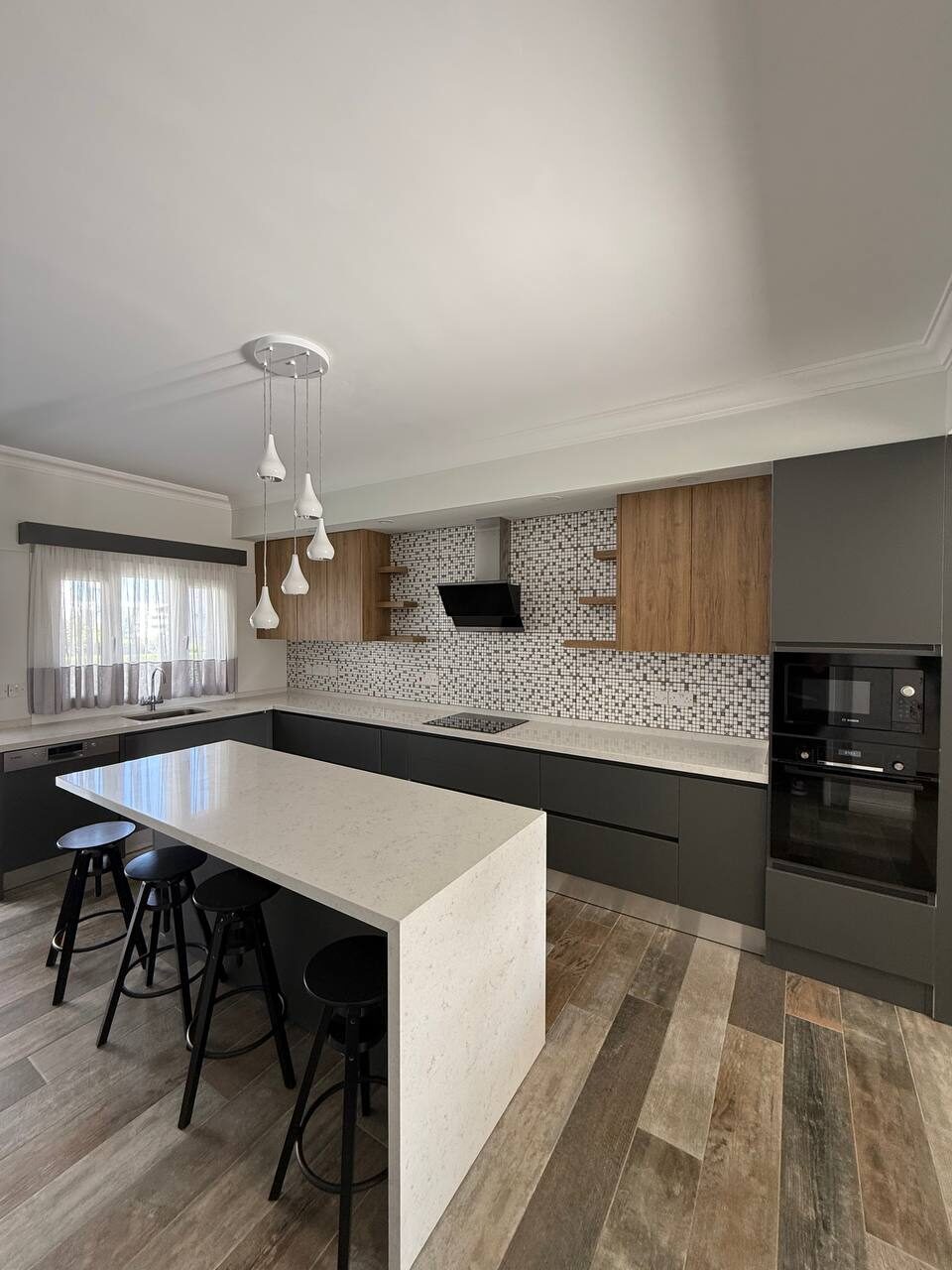 Kitchen area with pendant lights and a built-in oven