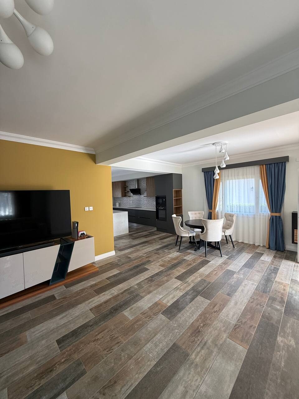 Living room with wooden flooring and a dining set by the window