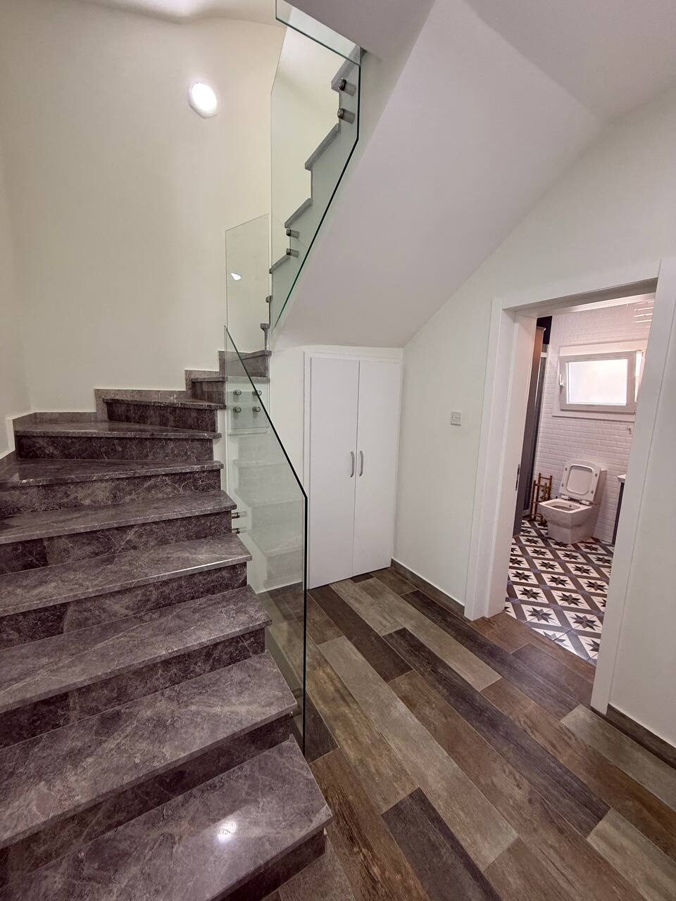 Staircase to the first floor with a glass balustrade