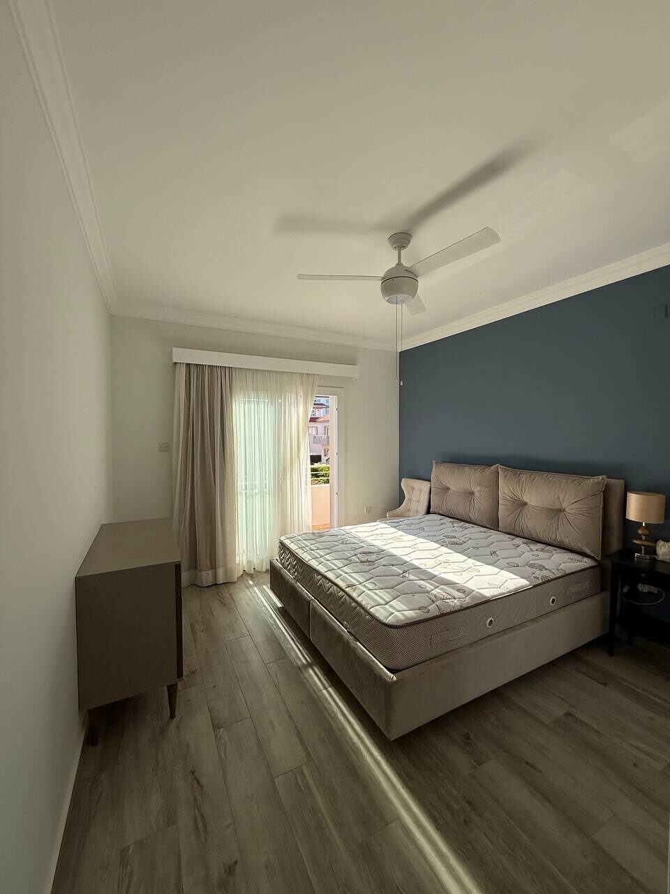 Bedroom with a bed and a full-height window with curtains