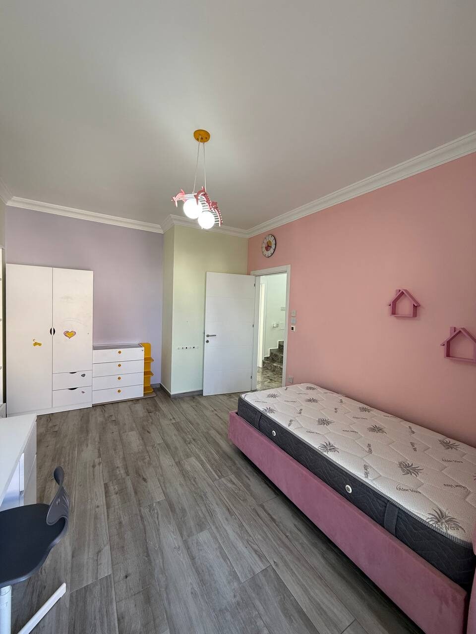 Child's room with a bed and wardrobe, door onto the balcony