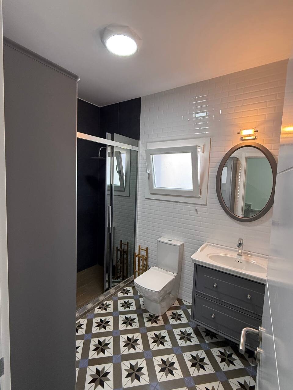 Bathroom with a shower enclosure and patterned floor tiles