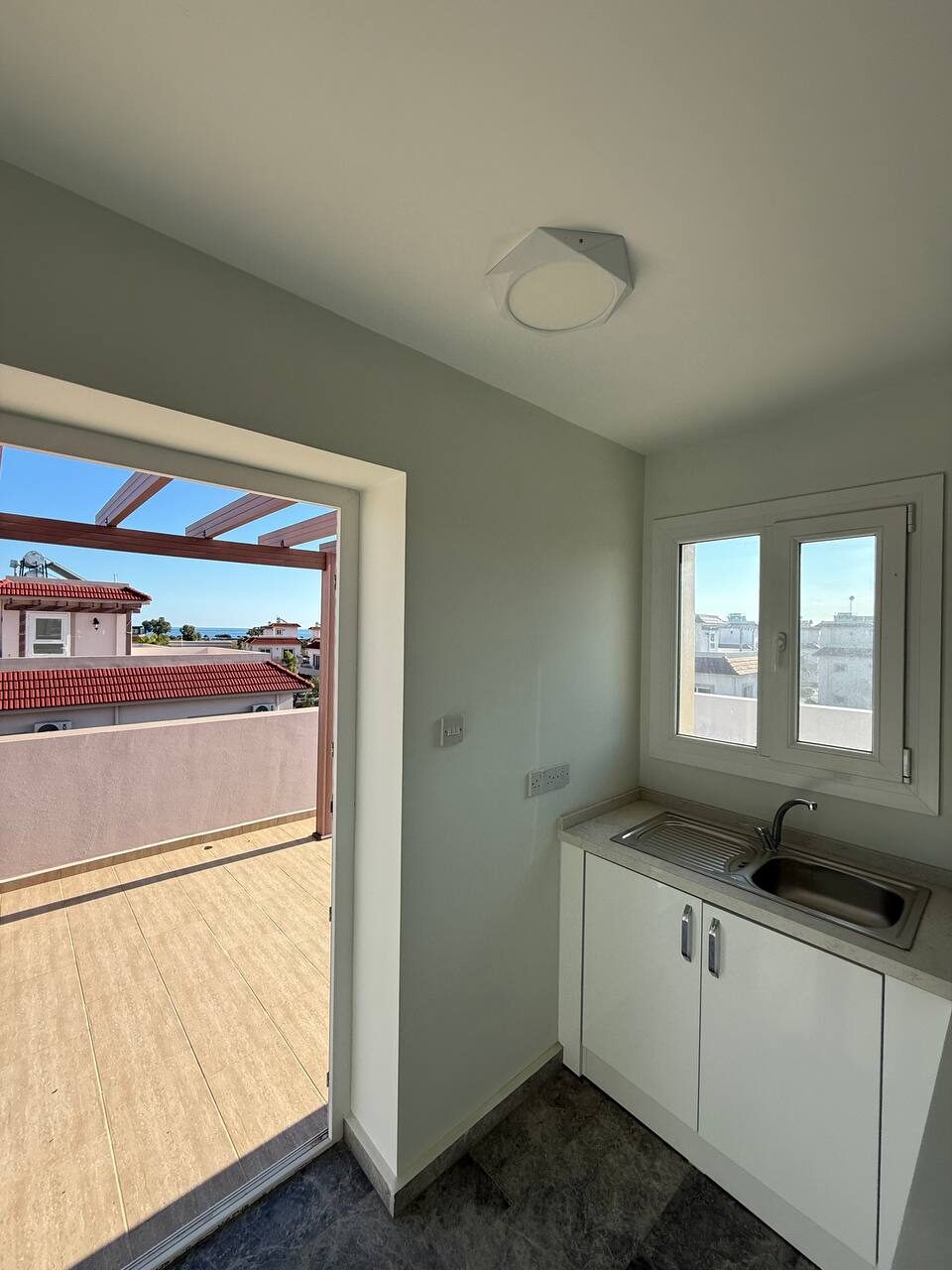 Utility room with a sink and a door onto the terrace